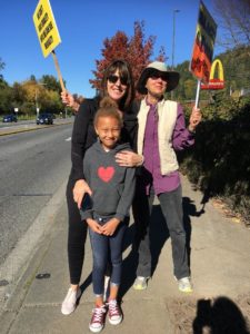 Adults and children hug, smile, and hold signs in support of Black Lives